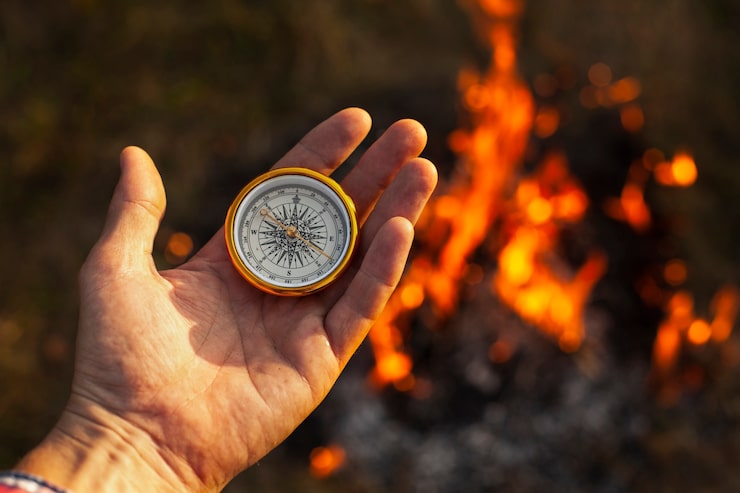 hand-with-compass-fire-flames-along_23-2148301457